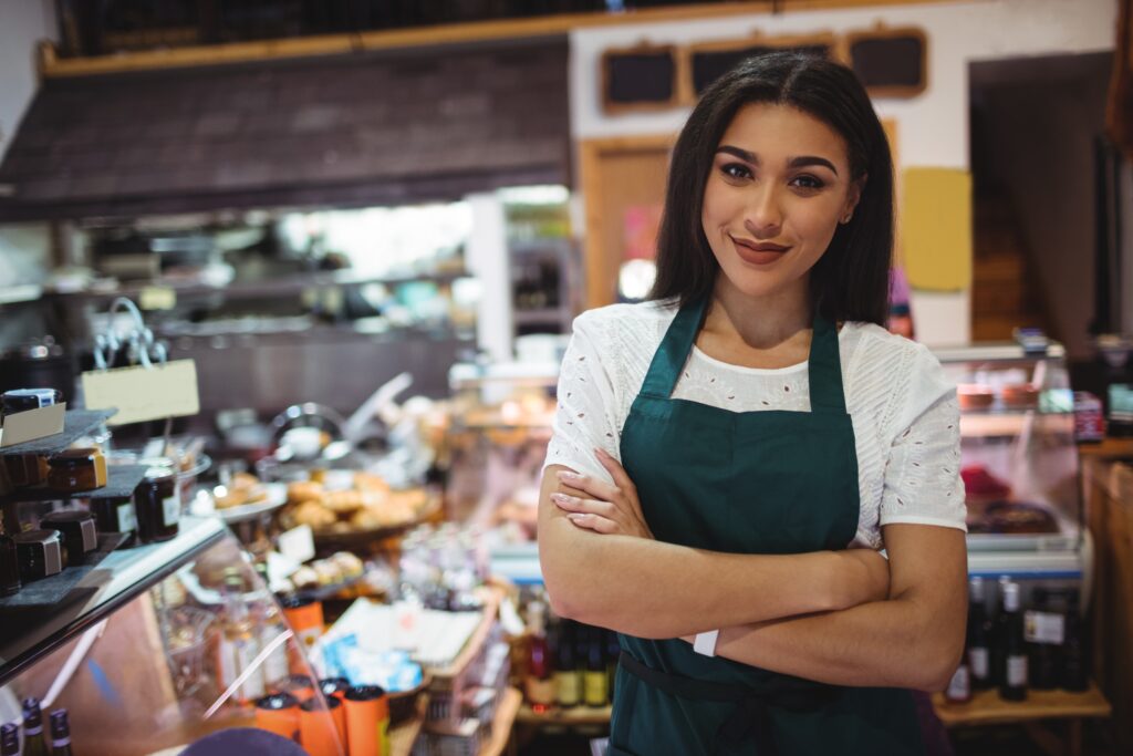 female-staff-standing-with-arms-crossed-in-super-market