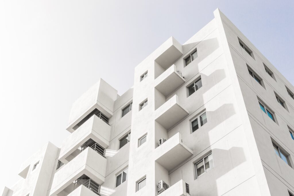 low-angle-shot-of-facade-of-white-modern-building-under-blue-clear-sky